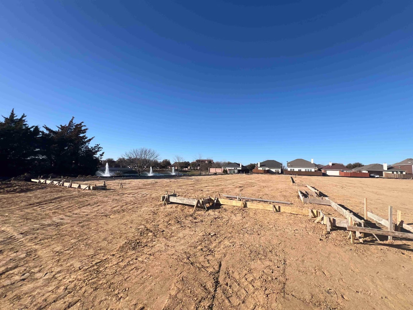 form boards on a construction site with houses in the background
